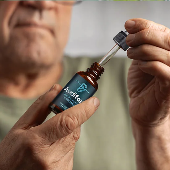 A man filling the dropper of an Audifort bottle